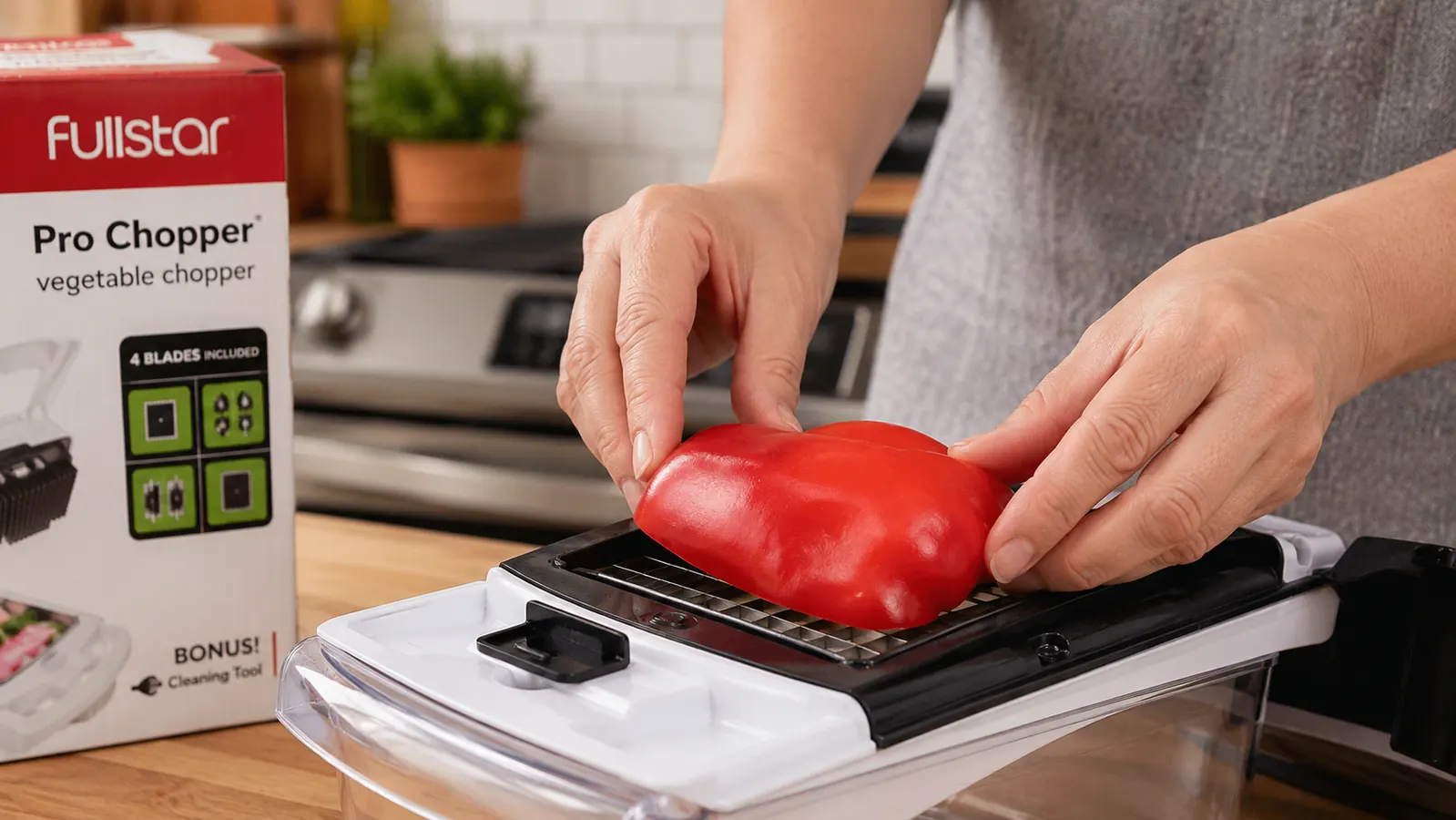 Person placing a quartered bell pepper skin-side up onto the Fullstar chopper blade before pressing