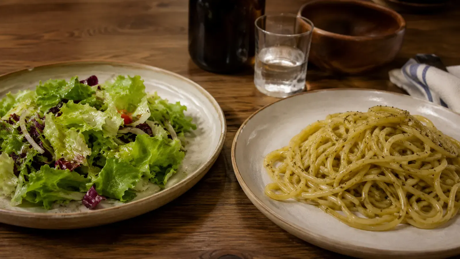 Two dinner plates side by side showing a lighter misted-oil meal versus a heavier poured-oil portion